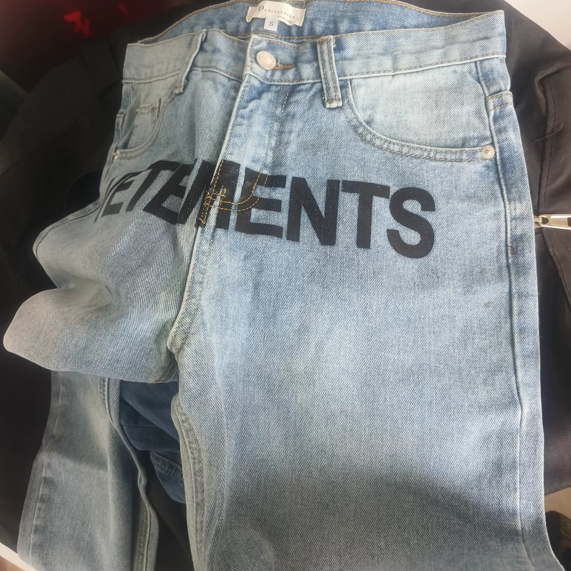 Джинсы VETEMENTS jeans S размера с оригинальным принтом крупными буквами спереди