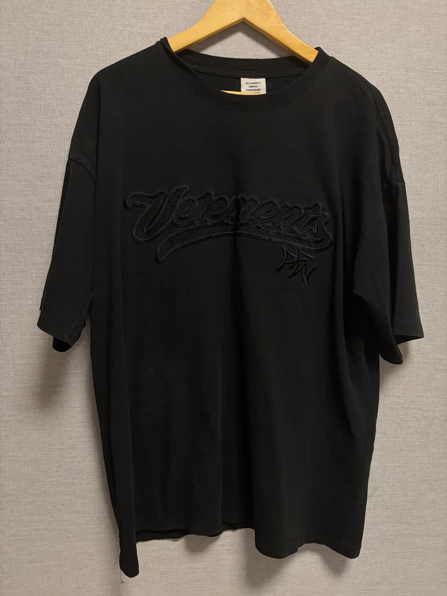 черная футболка с коротким рукавом, вышитая слоганом vetements