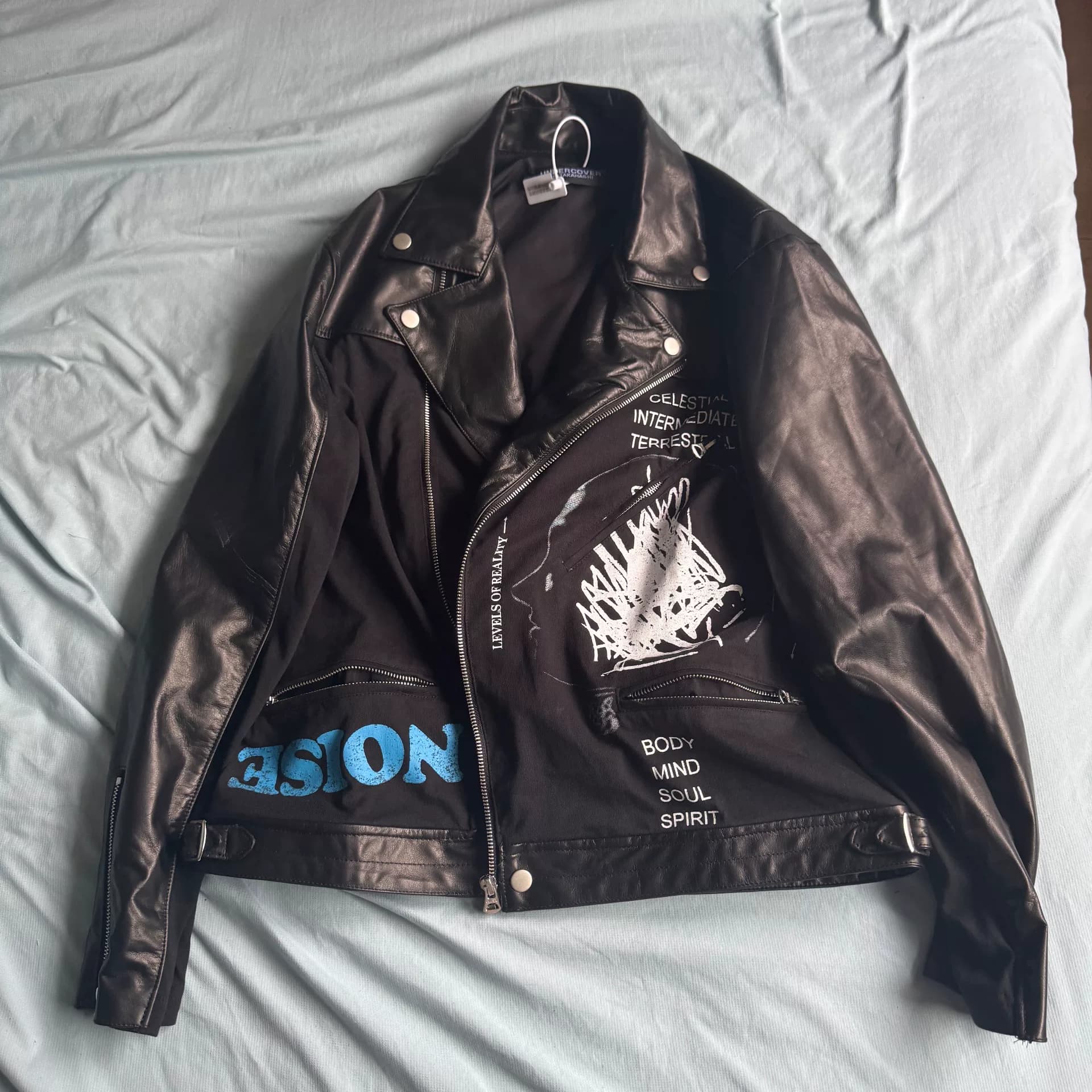 Из коллекции UNDERCOVER SN limited вышла черная мотоциклетная куртка в тон костюму от Kojima